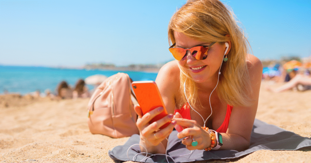 Mujer consulta en la playa el móvil