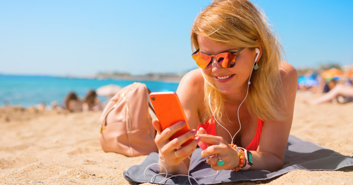 Mujer consulta en la playa el móvil